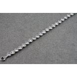 A silver and CZ bracelet, featuring round brilliant cut CZ stones in bevel settings, each stone