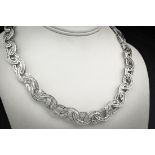 An 18ct white gold and diamond collar, the interlaced eliptical links set with baguette cut