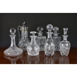 A collection of seven cut glass decanters and claret jug, the jug with silver plated mounts, the