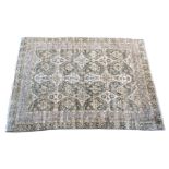 A large Oushak style rug, with two cruciform floral medallions on a sage green ground with all