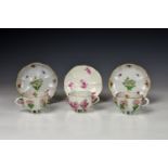 A pair of Meissen porcelain floral encrusted cabinet cups and saucers, early 'AR' mark but