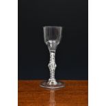 A mid-18th century opaque airtwist wine glass, c.1755, the half-fluted, ogee bowl on a double series
