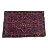A small antique Meshed rug, the claret red field with all over floral decoration and a large batwing