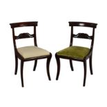 A pair of William IV mahogany label back side chairs, the scroll and floral carved top rails over