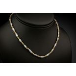 A 14ct gold and rice pearl necklace and bracelet, both with rice pearls alternating with pairs of