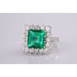 An exceptionally beautiful, rare and impressive emerald and diamond cluster ring, the step-cut