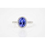 An 18ct white gold, Tanzanite and diamond cluster ring, the 2.01ct oval cut Tanzanite in a halo