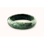 A contemporary jade bangle, of deep green and white marbled colouring and with a diameter of