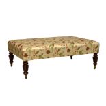 A large rectangular footstool, modern, upholstered in floral and foliate embroidered silk, raised on