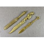 Three early 20th century brass letter opener's or paper knives, The largest with dragon haft, 9 7/