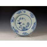 An 18th century Chinese blue and white porcelain charger, painted with a bird singing on a