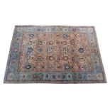 A large Veramin style wool rug, second half 20th century, the pale madder field with bold, all