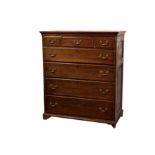 A George III oak tall chest of drawers, the moulded flared top over two panel sides and three