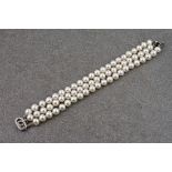 A three strand cultured pearl bracelet with silver clasp, each round pearl measuring approximately
