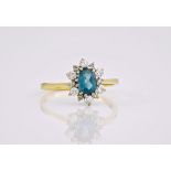 An 18ct gold, topaz and diamond cluster ring, the oval cut topaz surrounded by 12 brilliant cut