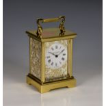 A Taylor and Bligh cased carriage clock, the bevelled glass with internally applied ornate gilt