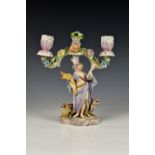 A Meissen style porcelain candelabra, the twin branch candelabra encrusted with flowers, a female