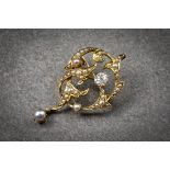 An antique 15ct gold, diamond and seed pearl pendant brooch, early 20th century, of scrolling