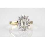 An 18ct gold and emerald cut diamond cluster ring, the central diamond of faint yellow colour and