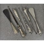 A collection of Victorian and later silver mounted button hooks and shoe horns by Crisford & Norris,