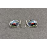 A pair of silver and enamel cufflinks depicting vintage racing cars, stamped 925, the oval form