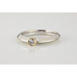 A 9ct yellow and white gold solitaire diamond ring, with a 0.10ct brilliant cut stone, on a bladed