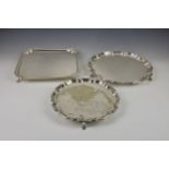 A silver plate square salver, on four feet below shaped edges, 11 5/8in. (29.5cm.) square,