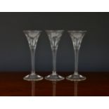A set of three mid-18th century engraved wine glasses, possibly Jacobite, the drawn trumpt bowls