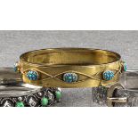 An antique 15ct gold and turquoise bangle, with eight oval turquoise clusters wrapped by rope