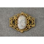 Two cameo brooches, the first with in rolled gold foliate designed filigree detailing to the setting