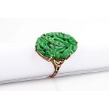 An Oriental 9ct rose gold and jade ring, the carved jade top of vibrant green colour and measuring