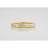 An 18ct yellow gold half eternity band, the baguette cut diamonds in a channel setting and totalling