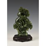 A Chinese carved jade style vase and cover, Qing style, 20th century, in mottled spinach green