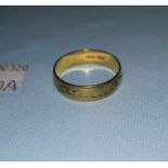 A gold wedding band with etched decoration, stamped 750 weight 5g