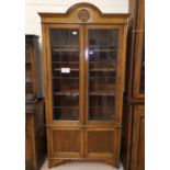 An Edwardian full height bookcase with 2 leaded glass doors and 2 panelled doors