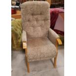 A modern high back deeply buttoned arm chair in fawn upholstery