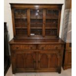 A Jacobean style carved oak dresser with 3 leaded glass doors, 2 drawers and double cupboard