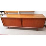 A 1960s teak long low line sideboard with tambour doors with four central drawers two with cutlery
