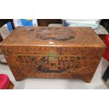 A large oriental carved camphor wood chest with extensive carving
