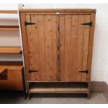 A rustic pine side cabinet with double cupboard and base drawer
