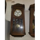 An early 20th century chiming wall clock in oak case; an oak cased barometer with thermometer