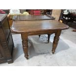 A Victorian oak extending dining table, one spare leaf, on turned legs