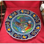A Persian large circular presentation charger depicting a mounted man hunting a lion, in original