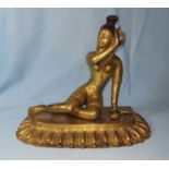 An oriental gilt bronze figure of a reclining female nude goddess, length 23 cm