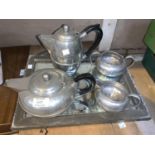 An "English Pewter" 4 piece beaten tea set; 2 large pewter plates; a pewter framed mirror