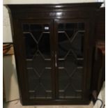 A 19th century mahogany straight front corner cupboard enclosed by 2 glazed doors