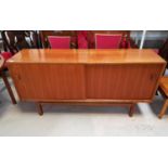 A 1960's teak sideboard with double sliding doors, drawers and interior shelves, by Nils Jonsson for