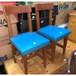 A pair of vintage child's chairs with blue cushions