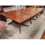 A Regency style large mahogany dining table on triple pedestal with splay feet and castors, extended