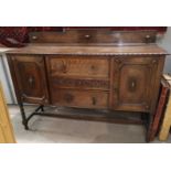 A 1930's Jacobean style sideboard of 2 cupboards and 3 central drawers